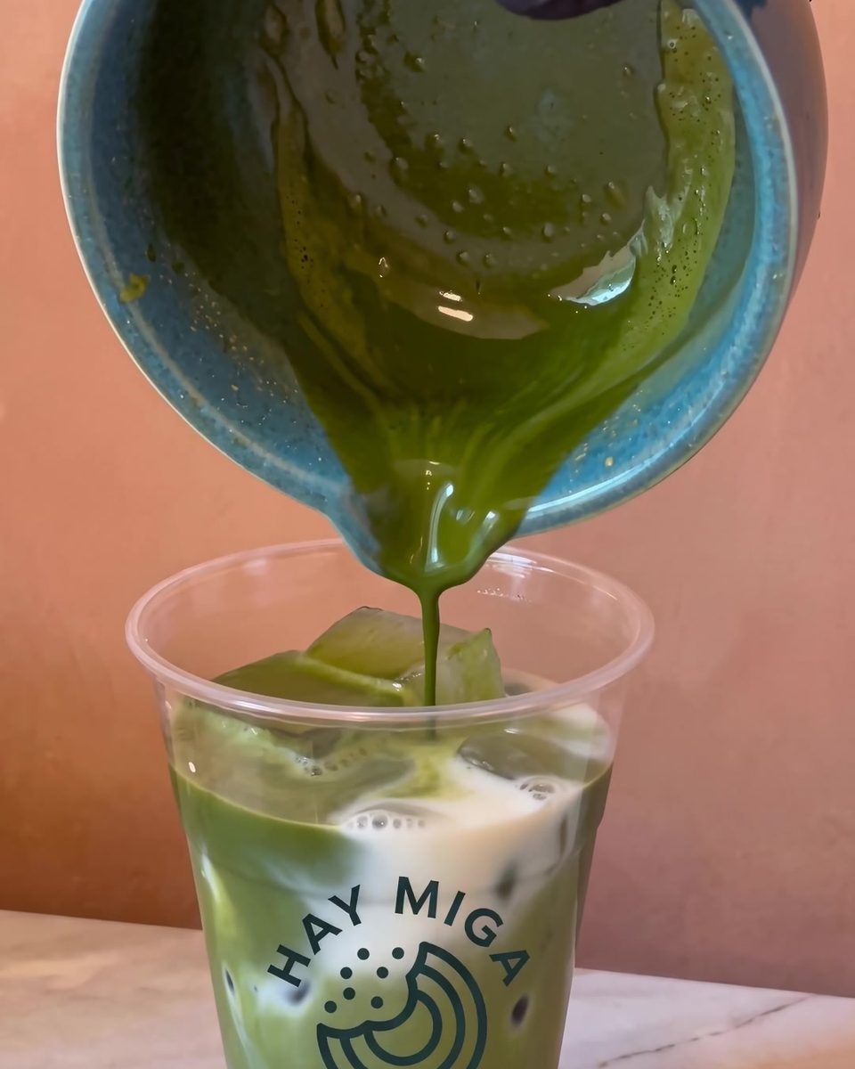 Matcha vertido sobre leche con hielo en un vaso de Hay Miga